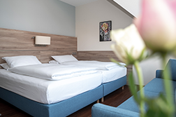 Ein großes Bett mit weißer Bettwäsche in einem hellen, freundlichen Zimmer.